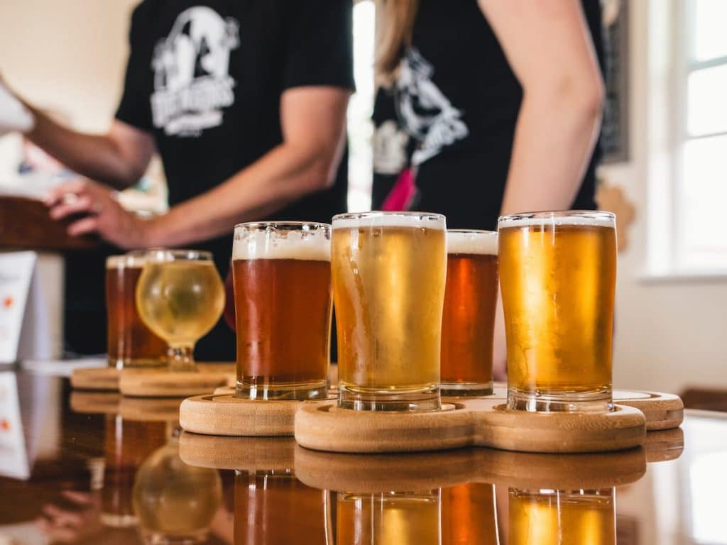 Diversos copos de cerveja em uma mesa de bar