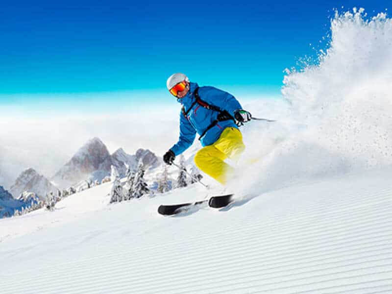 Homem praticando esqui na neve