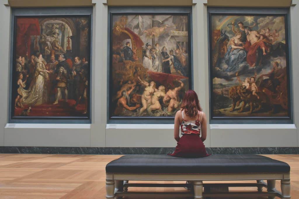 Mulher apreciando obras de arte em museus na Europa.