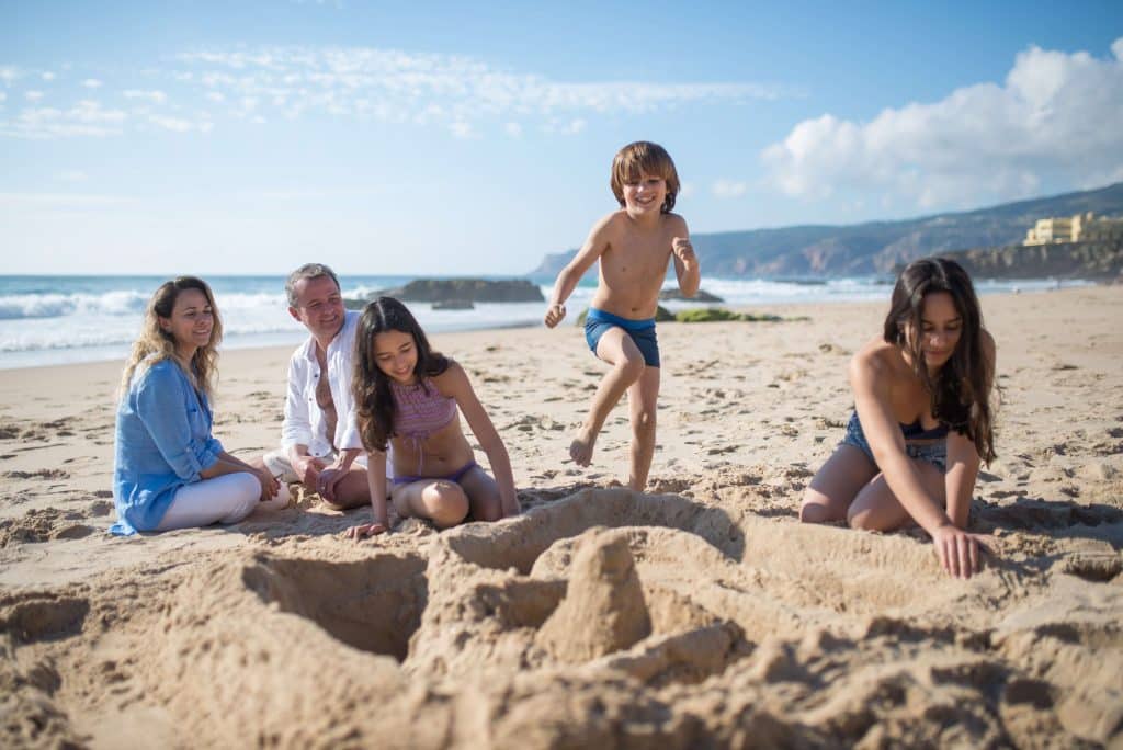 Crianças brincando na areia da praia.