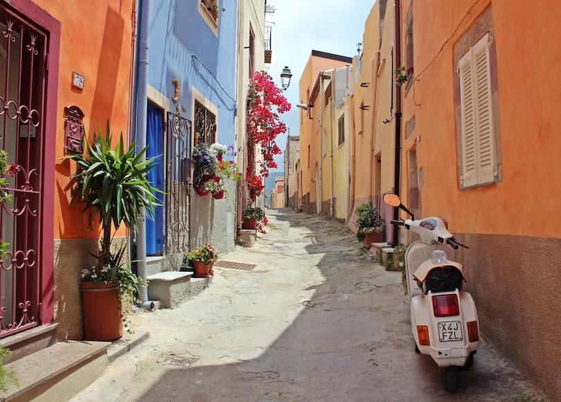 Rua na Itális com casas coloridas e moto