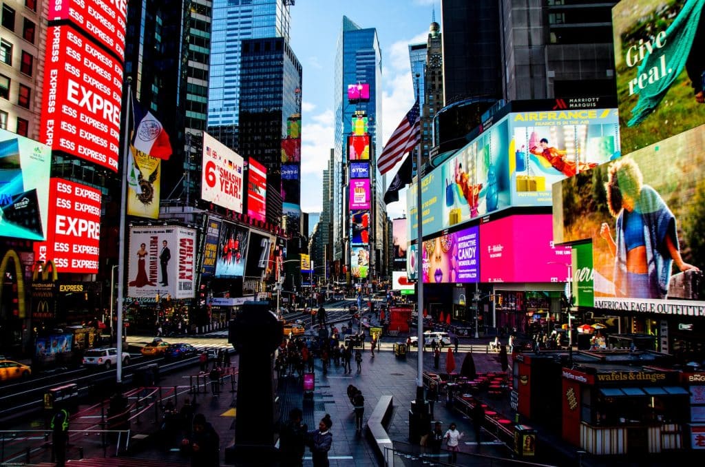EUA: Times Square - Região de Nova York com arranha-céus, diversas luzes e enormes painéis publicitários